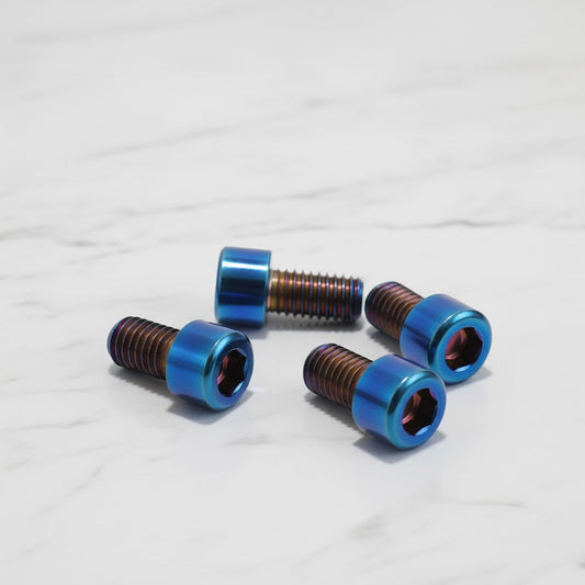 Four metallic screws with blue heads on a white background